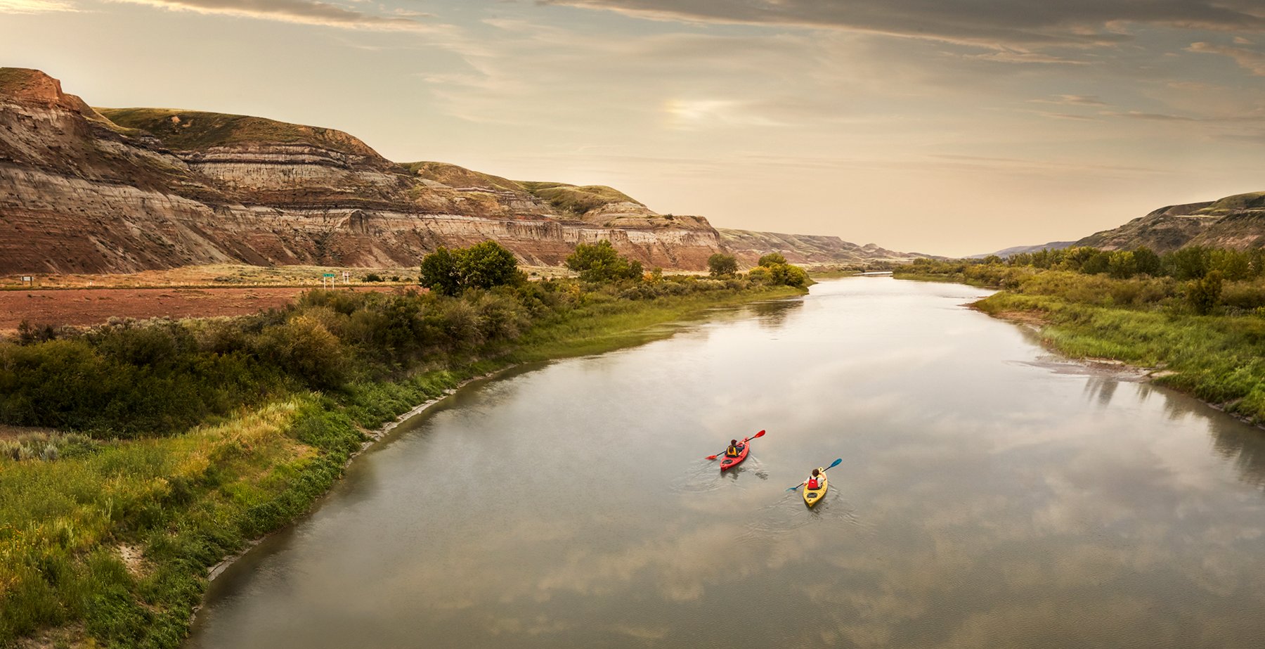 Scenic wide shot of people kayaking down the Red Deer River.