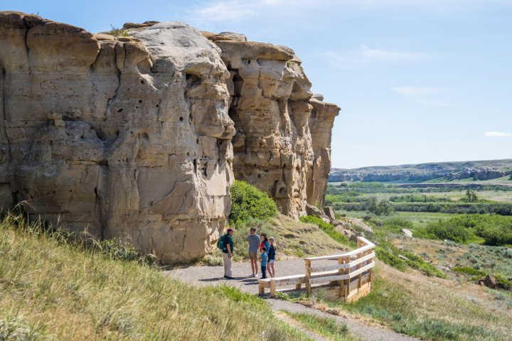 A family listening to their tour guide as they are shown hoodoos along a trail.