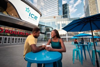 A young couple drinking coffee in the ICE District, in Edmonton