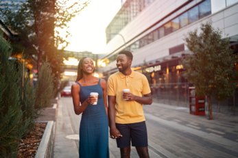 Couple walking in the ICE District with coffee in hand