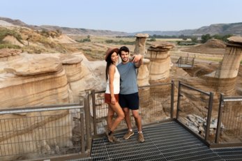 Young couple posing for a selfie on a platform along Hoodoo Trail in Drumheller.
