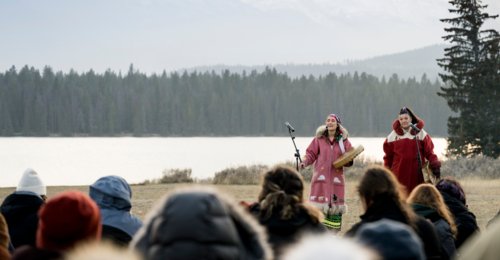 Wide shot of two indigenous women performers with audience