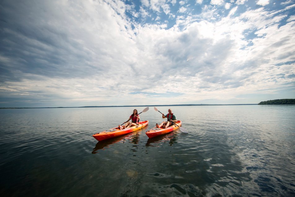couple tap oars as they kayak on Lac la Biche in sir winston churchill provincial park