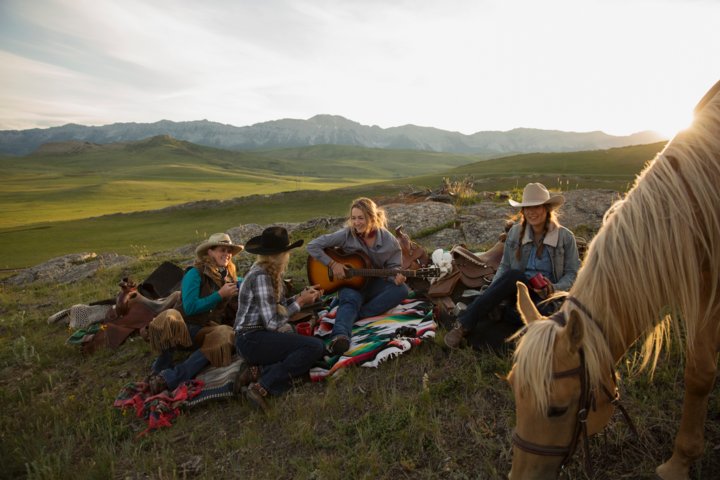 People relaxing and having picnic after horseback riding