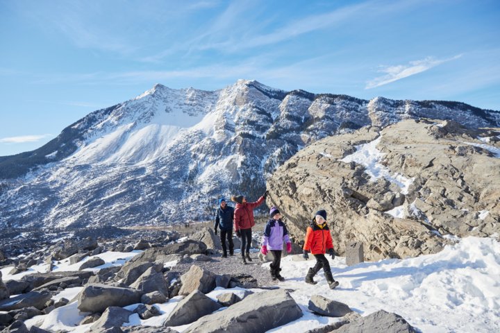 Family on a winter walk exploring interesting limestone formations from the aftermath of a historic rockslide