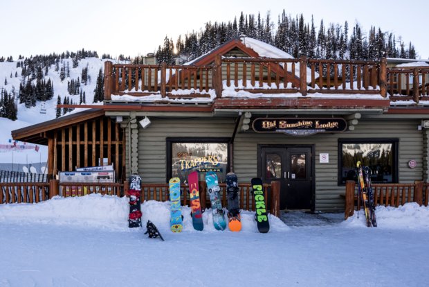 Snowboards leaning up against a restaurant at a alpine resort