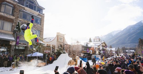 Spectators line the street in Banff, watching skijoring as a participant gets some air/tricks at the SnowDays Festival in Banff