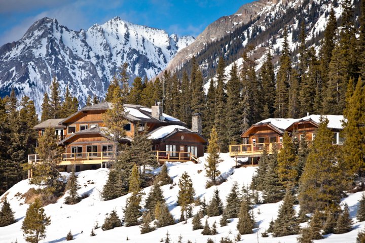 Exterior view of a lodge in the mountains on a sunny winter day.
