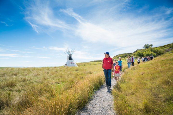 A school group walking the pathways at Head-Smashed-In Buffalo Jump with an Indigenous guide.
