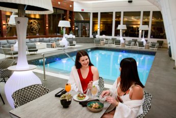 Two women eating lunch by the indoor pool at Hotel Arts.